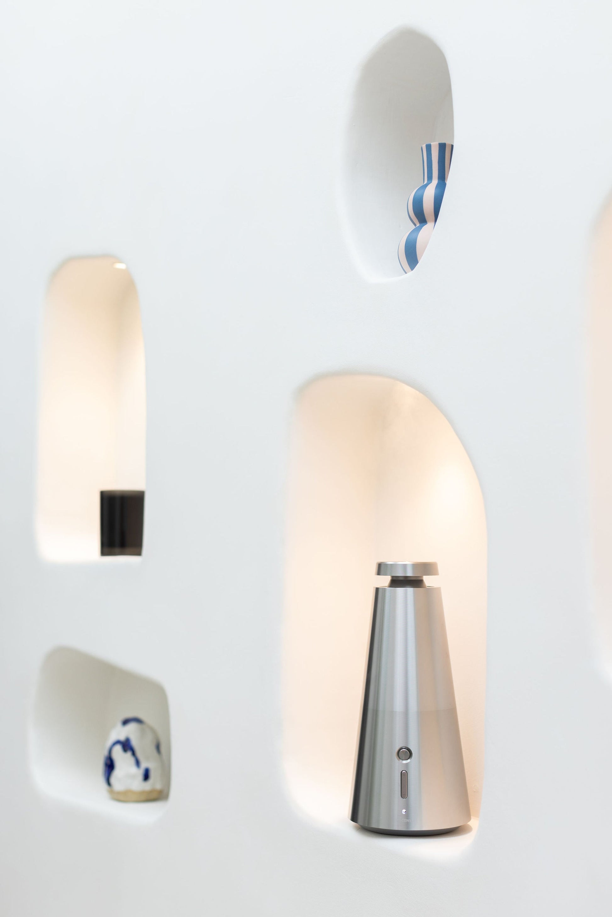 Silver Ensō Diffuser lit in a sculptural wall niche