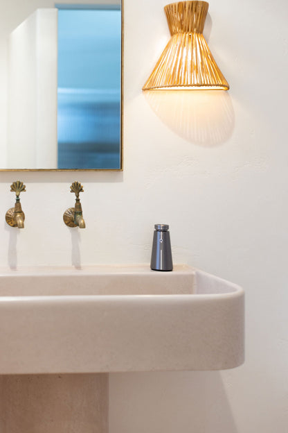 Ensō Mini on a washroom basin beside a rattan wall light