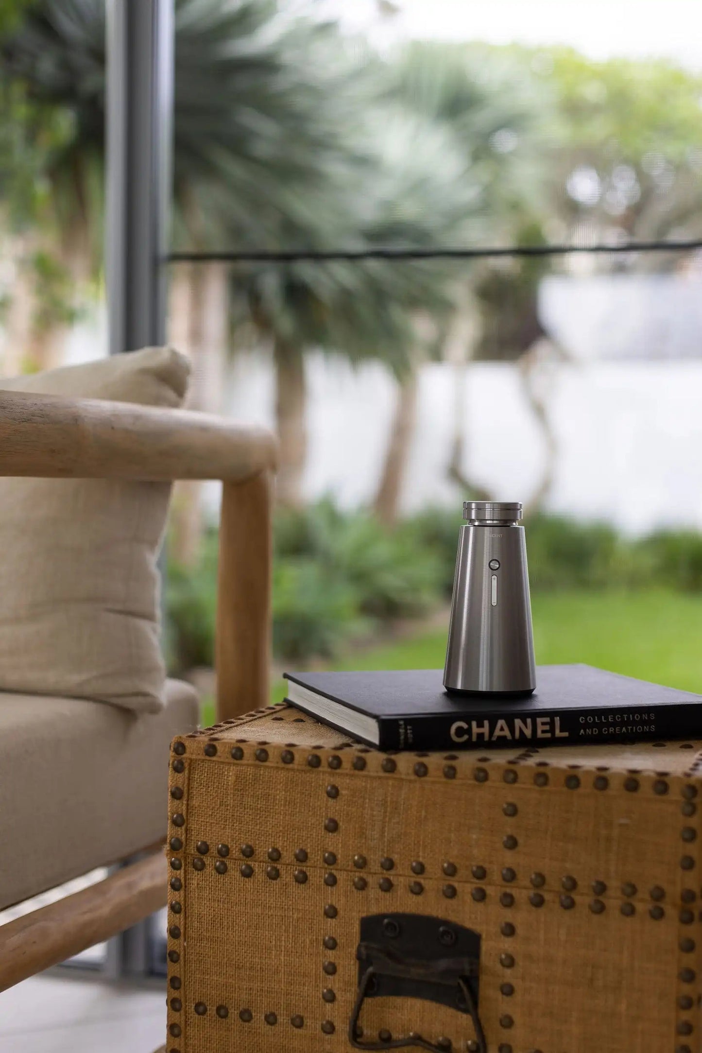 Silver Ensō Mini on a stack of books beside a garden seating area